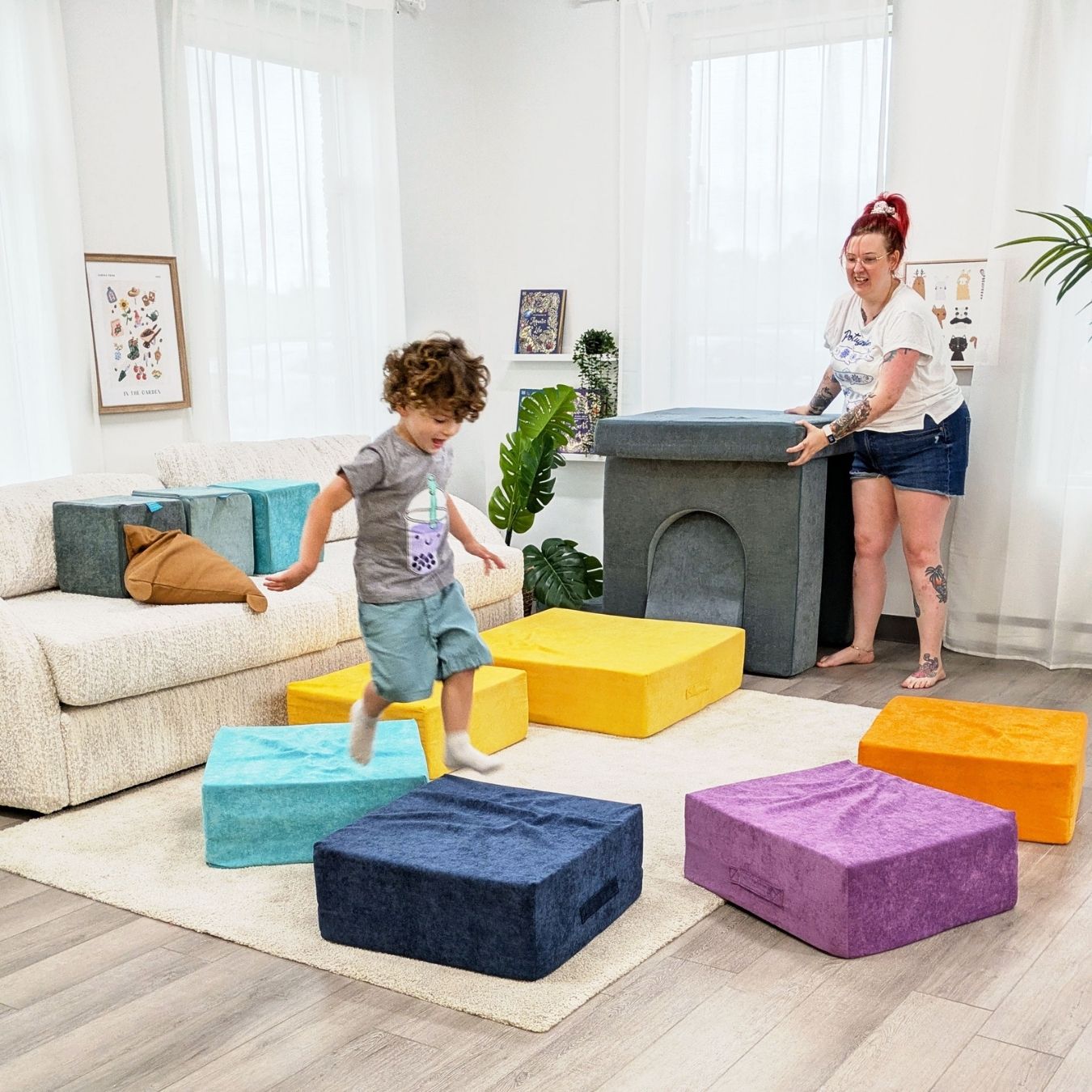 Children playing with colorful bouncing foam blocks in a living room.